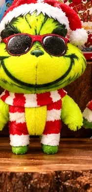 Green Christmas figure with sunglasses and a striped festive outfit