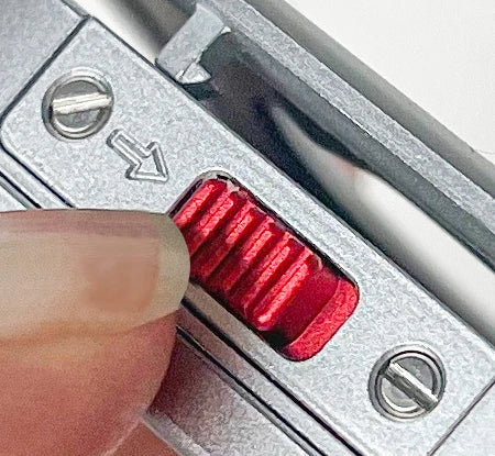 Original macro reference of the red sliding latch with a fingertip